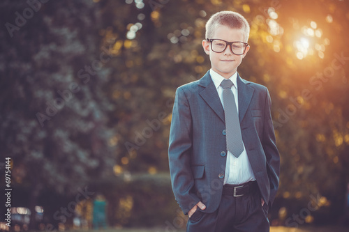 kid businessman with laptop on the park background
