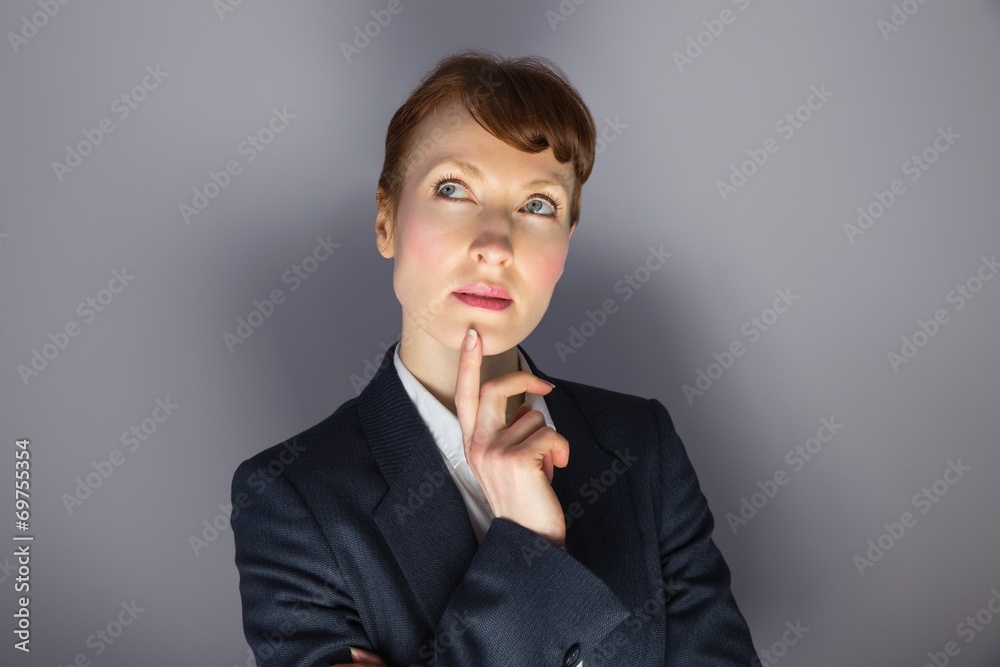 Businesswoman in suit thinking with finger on chin Businesswoman in suit thinking with finger on chin