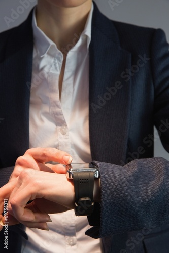 Businesswoman in suit checking the time