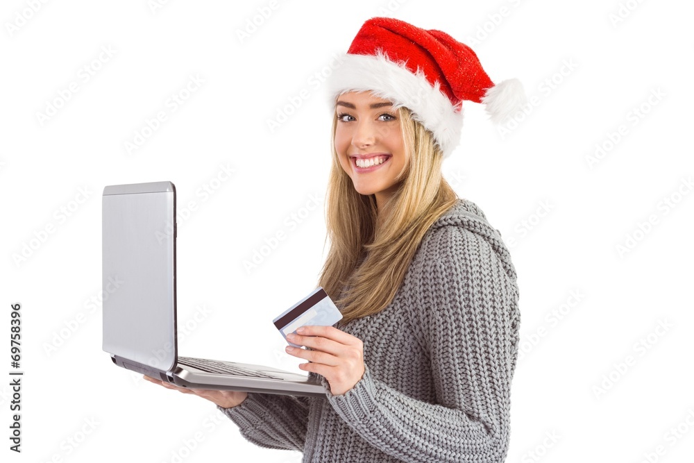 Naklejka premium Festive blonde shopping online with laptop