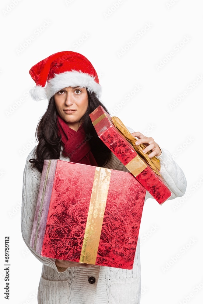 Confused woman opening christmas present Confused woman opening christmas present