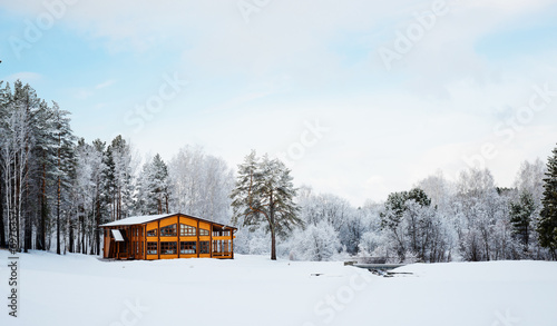 Wooden house in a nature area covered with freshly fallen snow. © Valeri Luzina