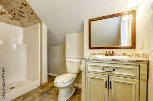 Fototapeta Naklejka Na Ścianę i Meble -  Bathroom with vaulted ceiling. Vanity cabinet and mirror
