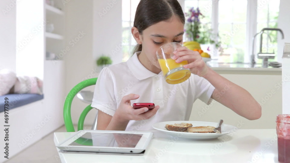 Schoolgirl With Digital Tablet And Mobile Eating Toast Schoolgirl With Digital Tablet And Mobile Eating Toast