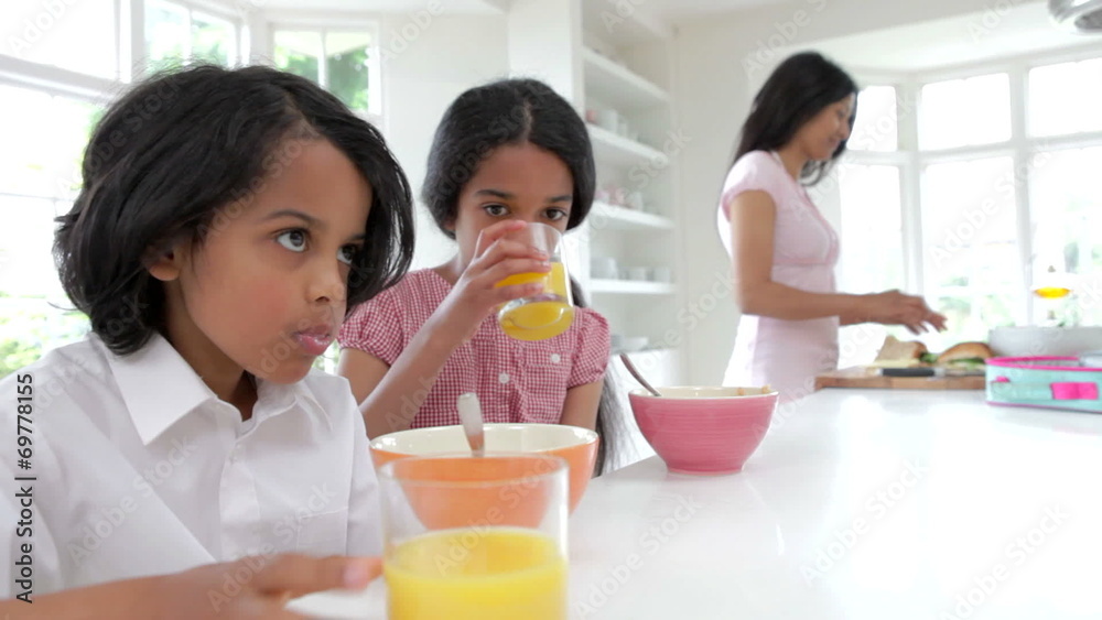 Schoolchildren Having Breakfast Whilst Mother Makes Lunch Schoolchildren Having Breakfast Whilst Mother Makes Lunch