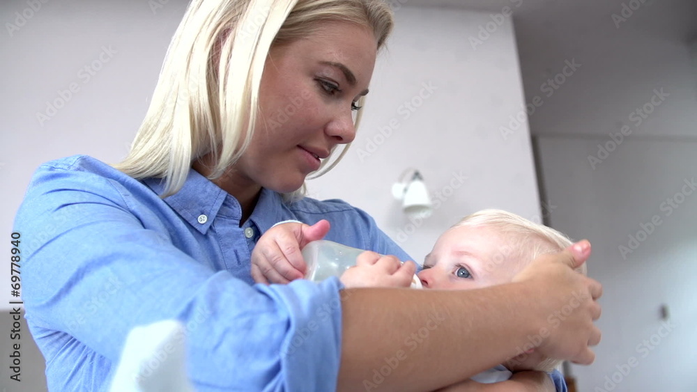 Mother Giving Baby Son Bottle Of Milk Mother Giving Baby Son Bottle Of Milk