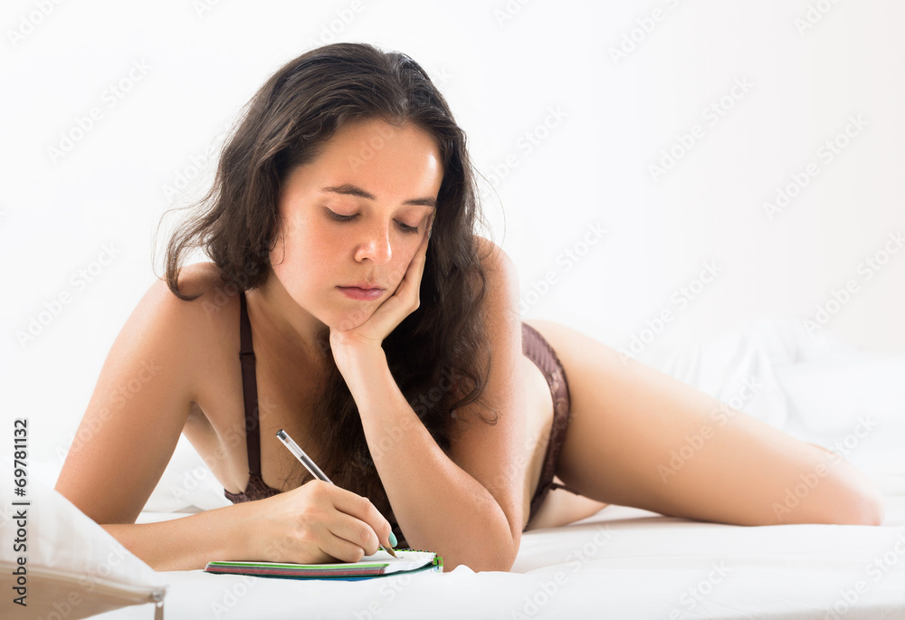 Fototapeta premium Brunette girl writing in notebok