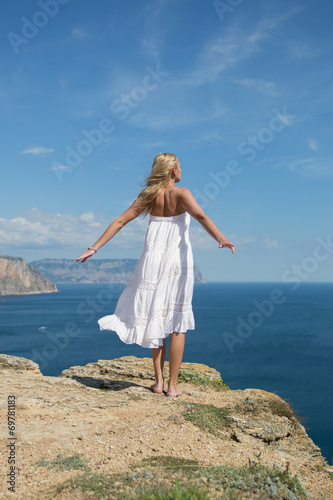Girl in white sundress on seashore
