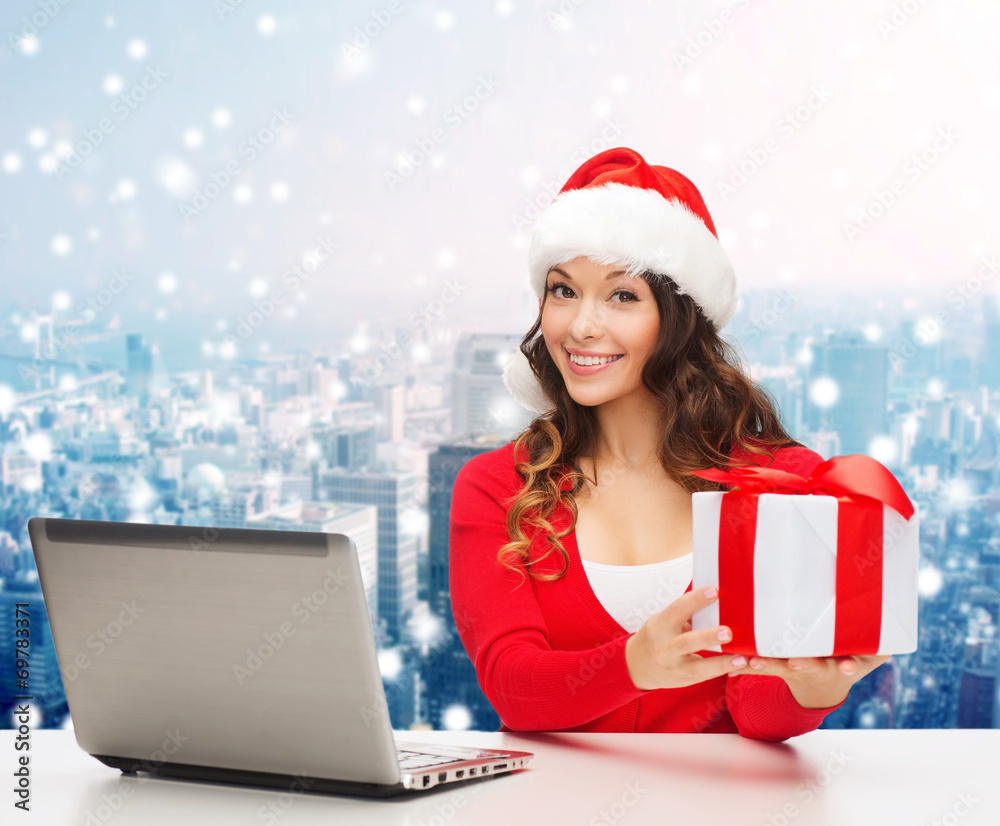 smiling woman in santa hat with gift and laptop smiling woman in santa hat with gift and laptop