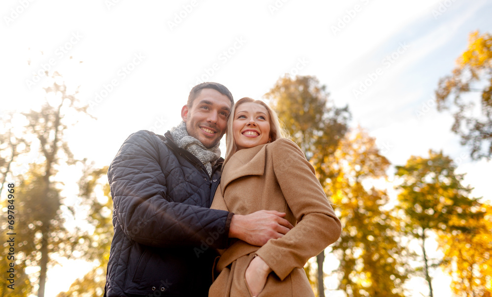 smiling couple hugging in autumn park