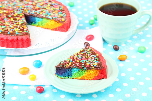 Delicious rainbow cake on plate  on tablecloth background