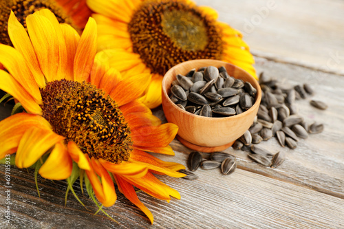 Fototapeta Naklejka Na Ścianę i Meble -  Sunflowers and seeds in bowl on wooden background