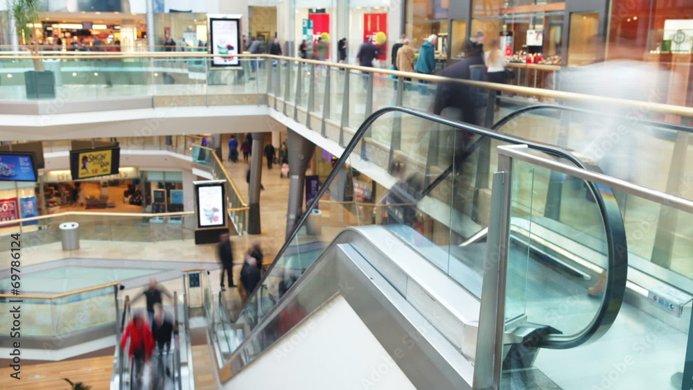 Time Lapse Sequence Of Shoppers On Escalators In Mall