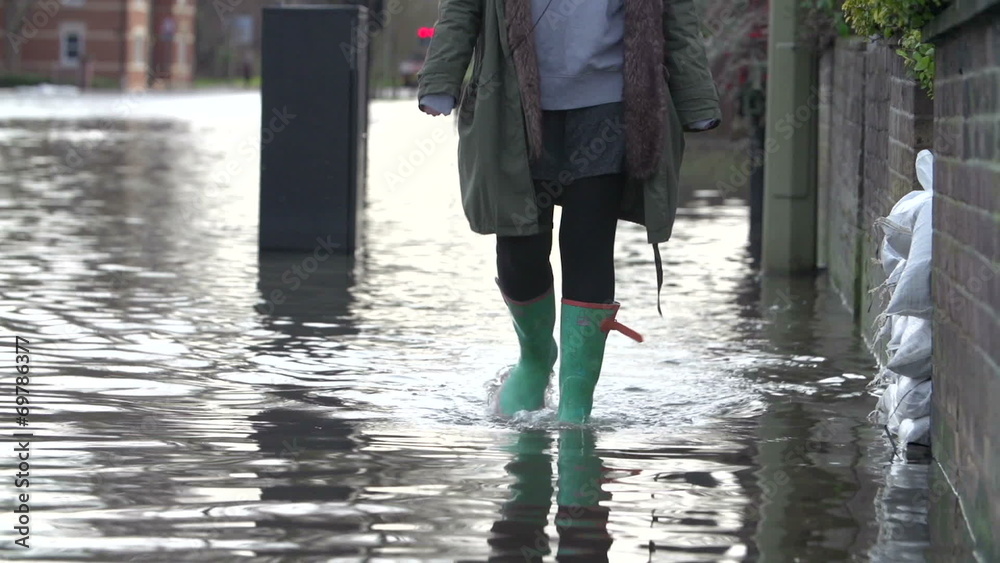 Slow Motion Sequence Of Boots Walking Along Flooded Road 