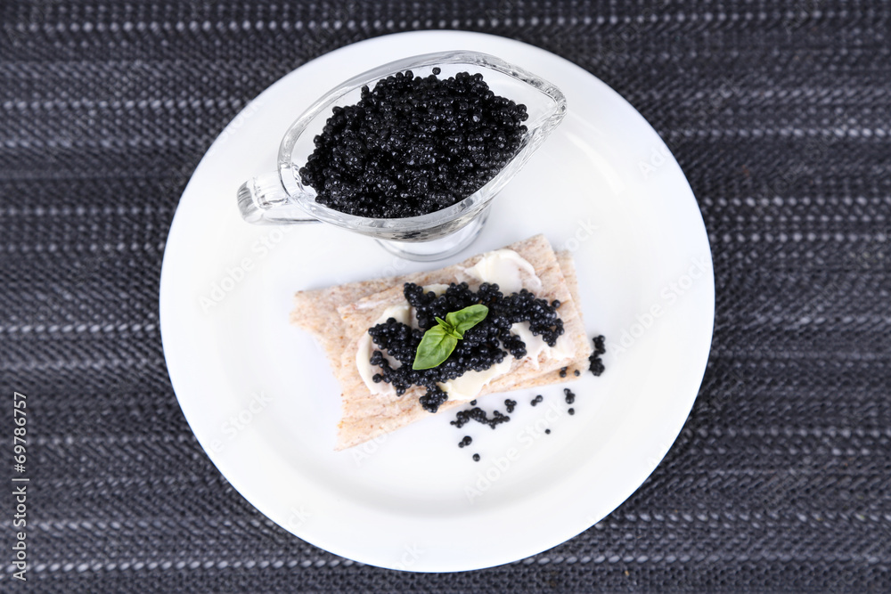 Slice of bread with butter and sauceboat with caviar Slice of bread with butter and sauceboat with caviar