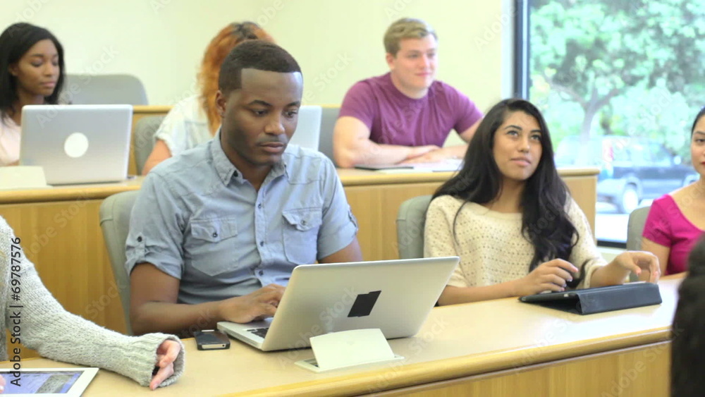 Students Using Laptops And Digital Tablets In Lecture Students Using Laptops And Digital Tablets In Lecture