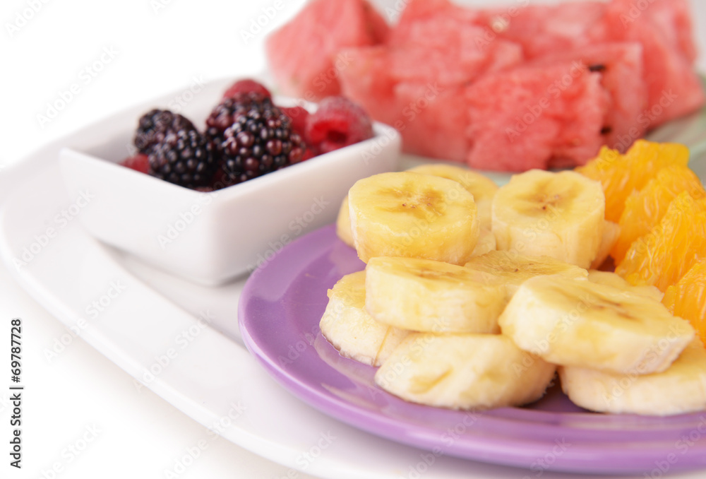 Slices of fruits with berries on plate close up Slices of fruits with berries on plate close up
