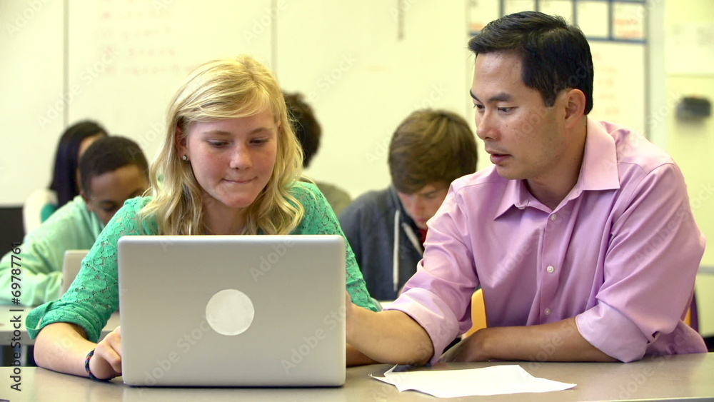 Female High School Student With Teacher Using Laptop Female High School Student With Teacher Using Laptop