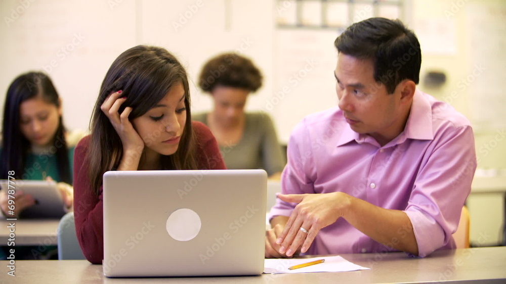 High School Teacher Helping Stressed Pupil In Class High School Teacher Helping Stressed Pupil In Class