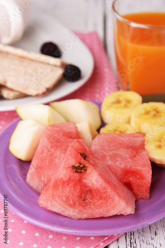 Slices of fruits with crispbreads and glass of juice