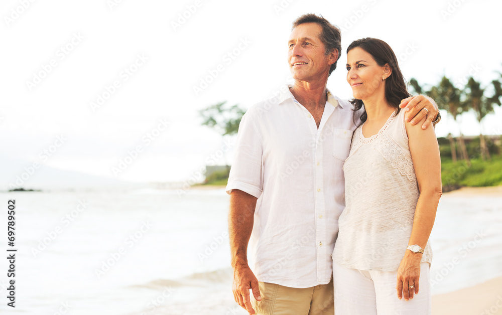 Obraz premium Mature Couple Enjoying Sunset on the Beach