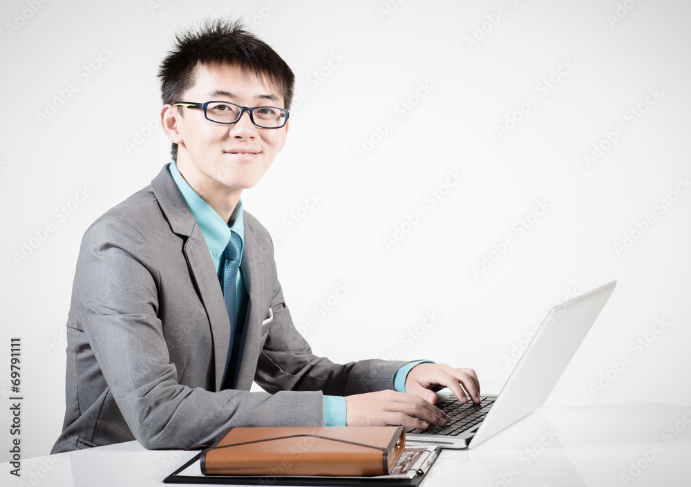 Asian business man using laptop computer isolated on white backg Asian business man using laptop computer isolated on white backg