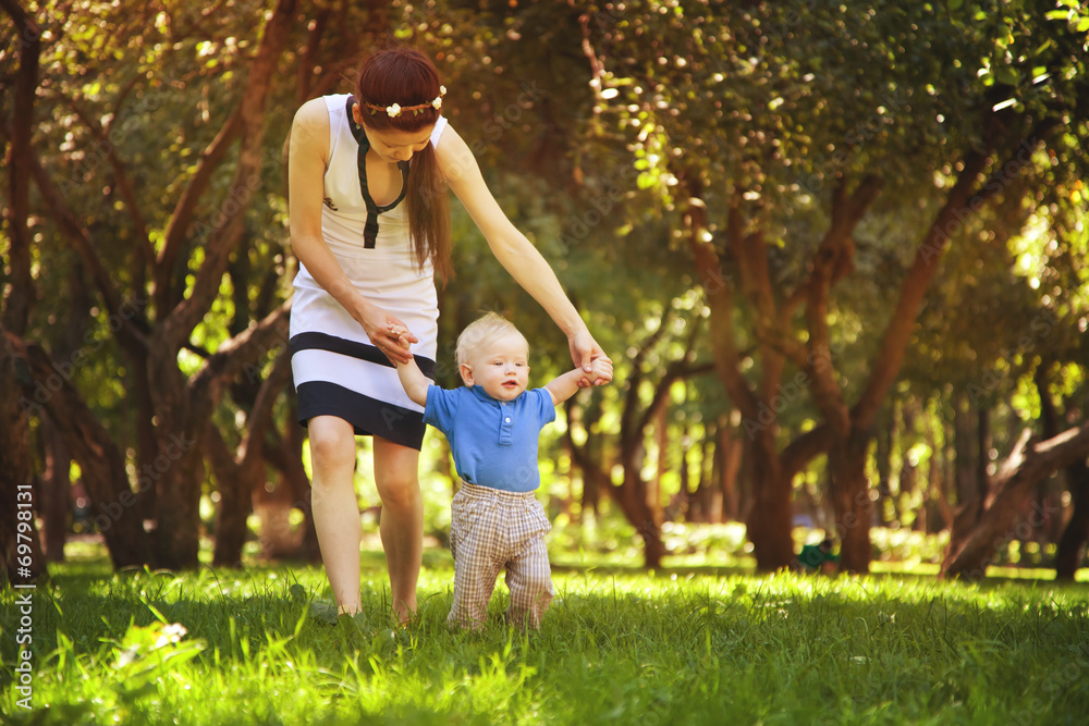 Fototapeta premium year-old boy toddler learning to walk in the park