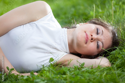 young woman sleeping on grass
