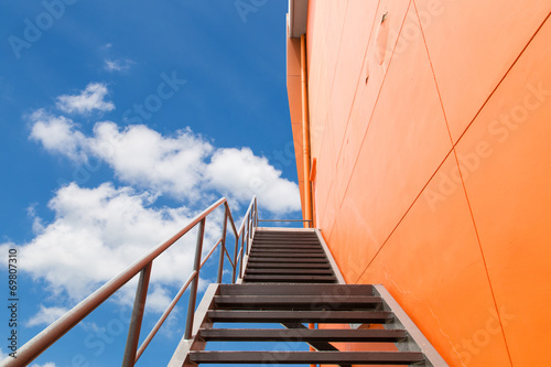 Metal fire escape or emergency exit on Orange Wall of Buliding