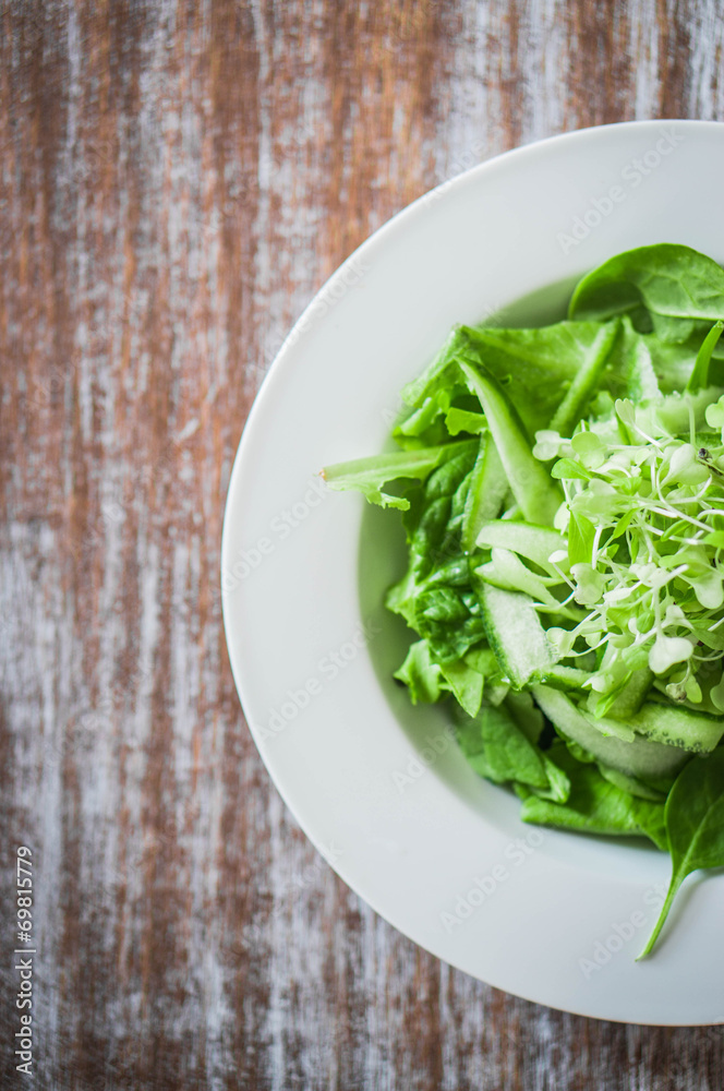 Salas with spinach,cucumber and microgreens on wooden background Salas with spinach,cucumber and microgreens on wooden background