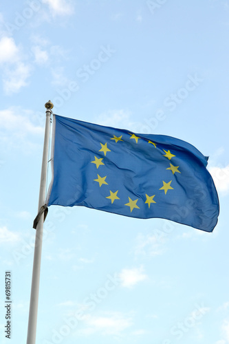 The flag of the European Union flutters against the blue sky