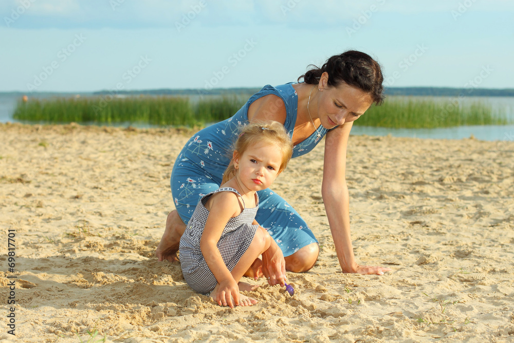 Mother with children playing with sand on beach Mother with children playing with sand on beach