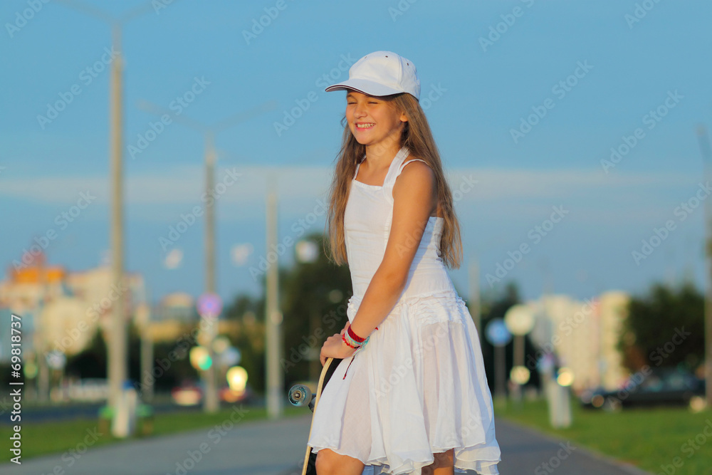 teenage girl riding a skateboard on the evening street