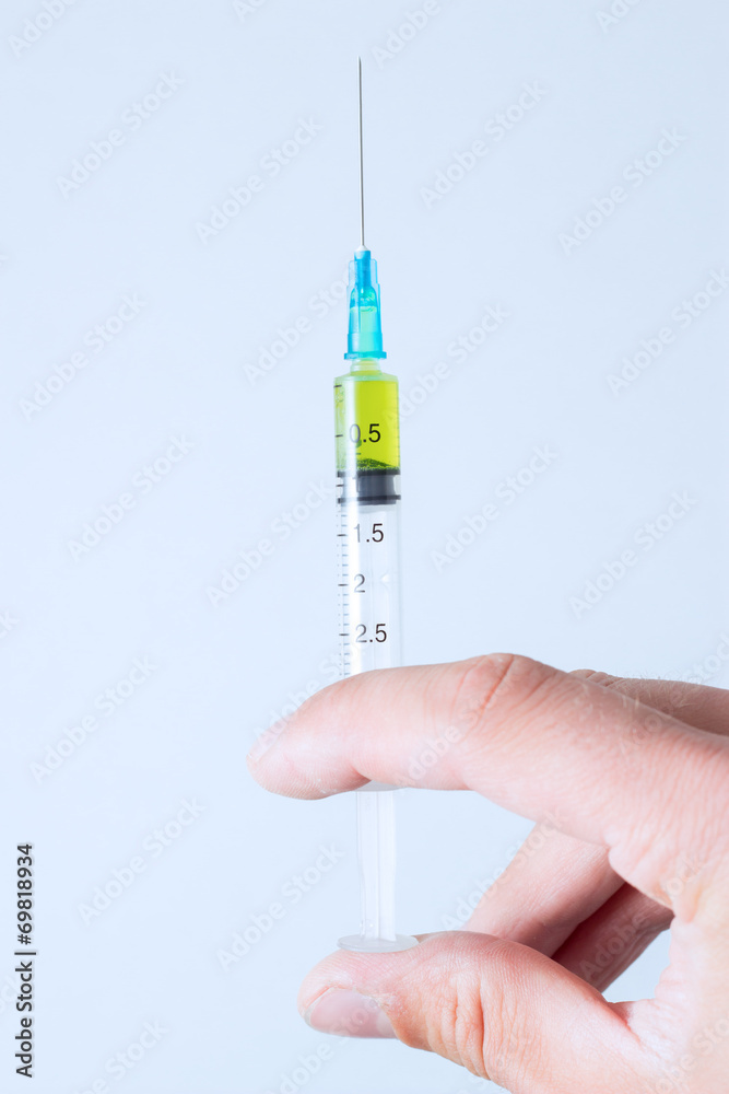 Syringe with the vaccine in hand - Stock Image Syringe with the vaccine in hand - Stock Image