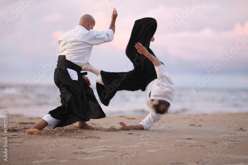 Master doing throwing technique, his partner in the air