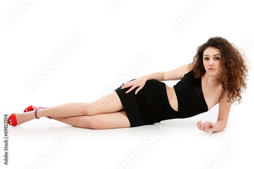 A girl in a black dress in the studio on a white background.  © Artgo