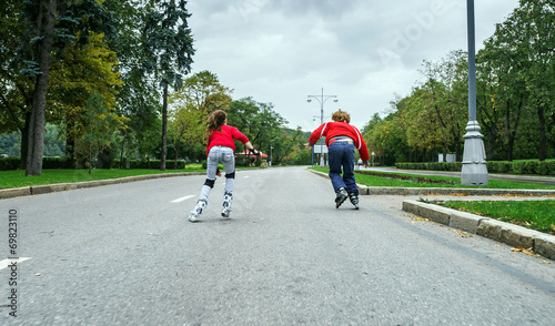 Group of children rollerskating in public park