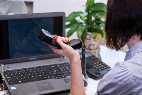 female office worker looking at the laptop screen with charts