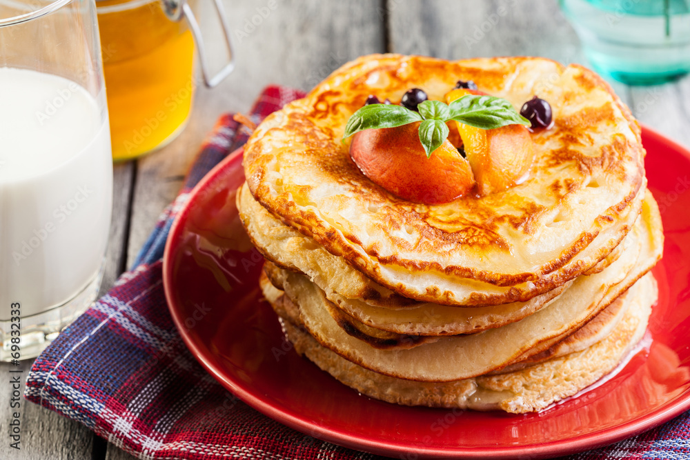 Pancakes with honey, fruit and glass of milk Pancakes with honey, fruit and glass of milk