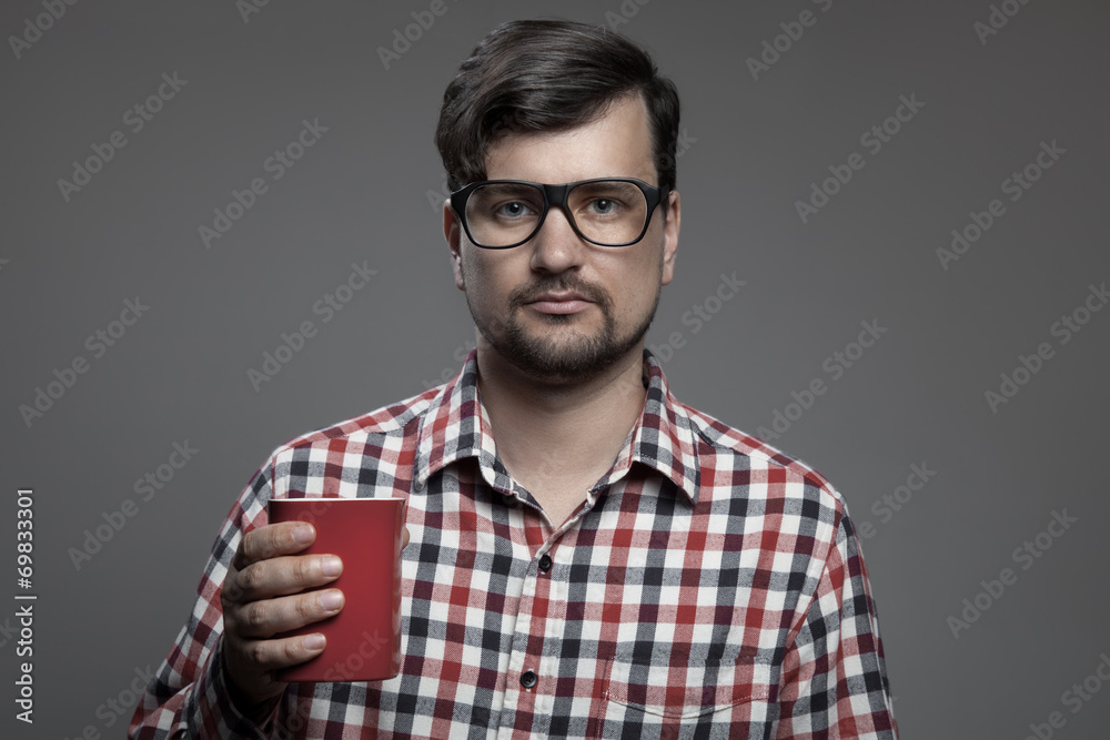 Obraz premium Handsome hipster modern man and cup of coffee in hand.