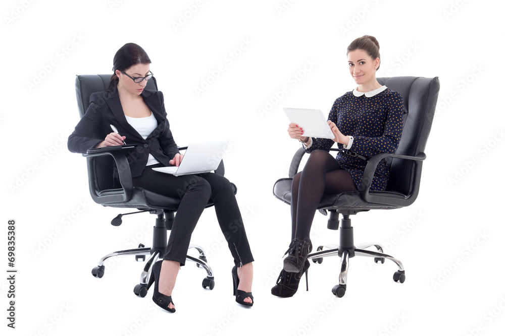 two beautiful business women sitting on office chairs with table two beautiful business women sitting on office chairs with table
