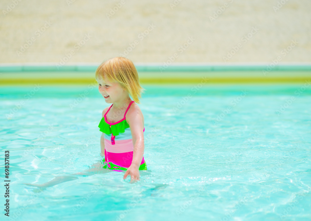 Baby girl playing in swimming pool