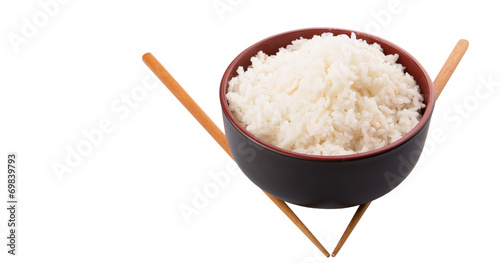 A bowl of rice and a pair of chopstick over white background