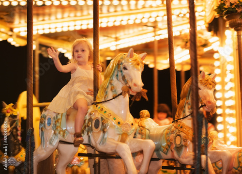 Portrait of happy baby girl riding on carousel photo