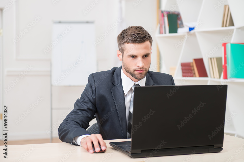 Businessman sitting at the table and working with laptop in offi Businessman sitting at the table and working with laptop in offi