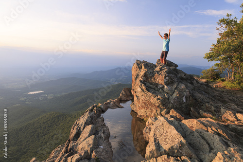 A teenager standing on the edge of a cliff photo