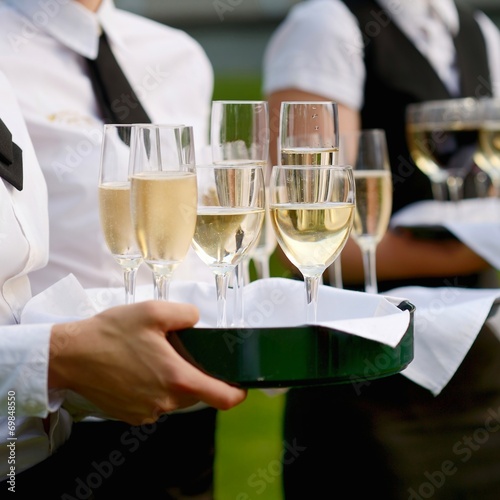 Waitress with dish of champagne glasses