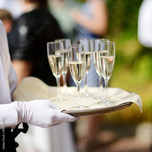 Waiter with dish of champagne glasses