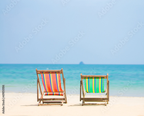 Fototapeta Naklejka Na Ścianę i Meble -  Bright color wooden beach chairs on island tropical beach