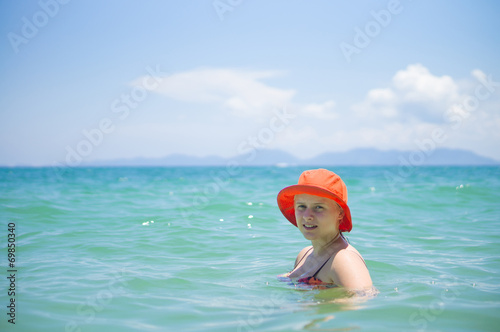 Young woman in orange hat swim in tropical ocean © Joshhh